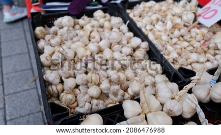 There are loads of garlic in a crate laid out on the counter at the local market. These garlics are a natural source of antibiotics. It is very useful to consume garlic against diseases in winter. Stok fotoğraf © 
