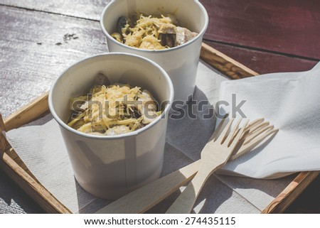 street food festival super tasty noodles pasta with chicken sau?e and cheese italian cuisine meal on a wood background and wooden forks