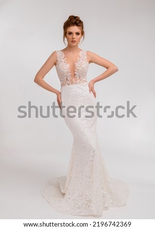 Beautiful bride lady posing in an elegant white wedding dress with lace in spacious studio room looking into camera having stylish wedding haircut. Bride woman model. Full length bride portrait. Photo stock © 