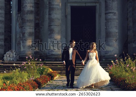 bride happily go hands on background of the old church