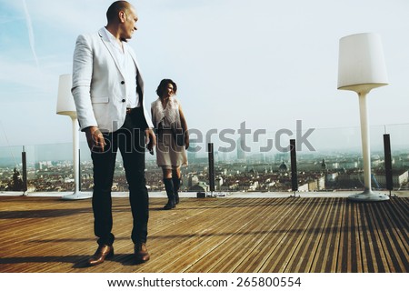 wonderful rich groom looking at bride on the terrace on the background of blue sky Lyon city
