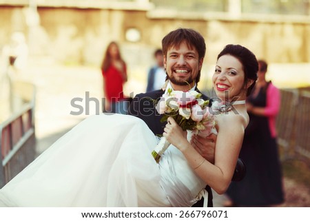 cute rich happy groom holds a bride smiling sunny Rome smiling and look at each other