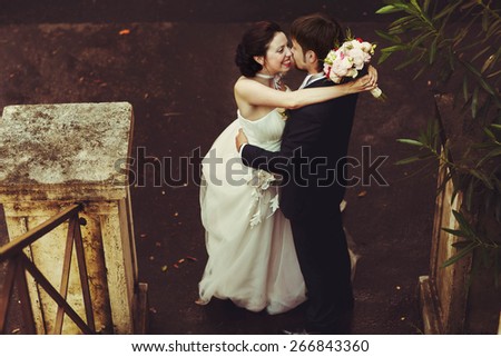 cute sweet happy bride and groom kissing and hugging on the old street in Rome Italy