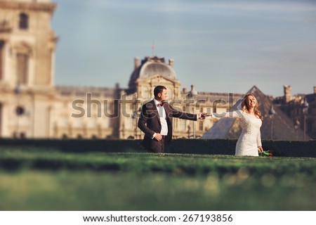 happy wedding couple holding hands in Paris