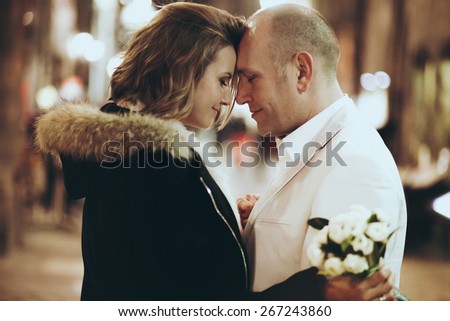 stylish beautiful happy bride and groom walking and hugging on the streets Lyon evening lights shine
