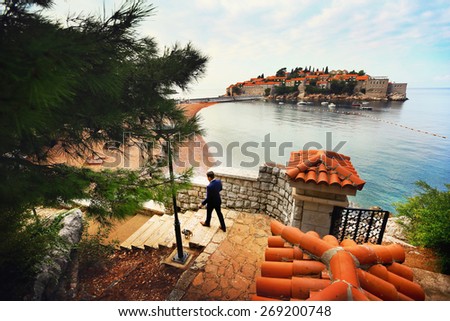 stylish rich groom goes down the stairs on the banks of Montenegro