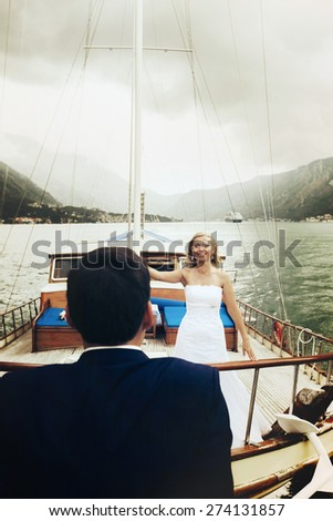 Stylish young bride and groom huging and smiling on board the yacht Montenegro on board the yacht Montenegro
