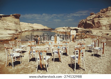 vintage decor wedding ceremony on the bank on the background of the sea near the island of Milos Greece rocks