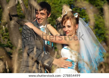 bride and groom smiling  on the background trees and herbs
