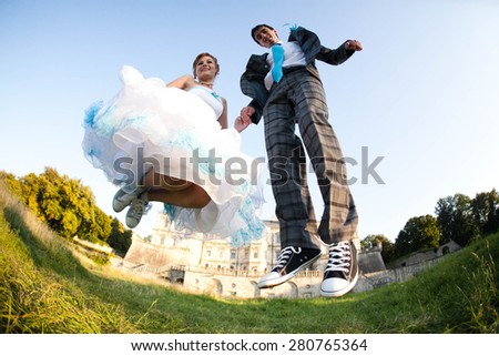 fun couple is jumping on background old castle