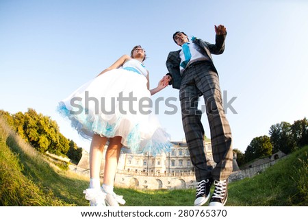 smiling couple is jumping on background old castle