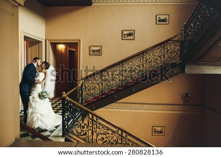 groom and bride hugging and kissing on the  background corridor