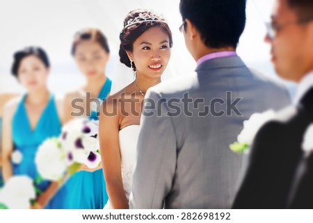 stylish rich smiling asian bride and groom  wedding look at each other in island Santorini greece sunshine