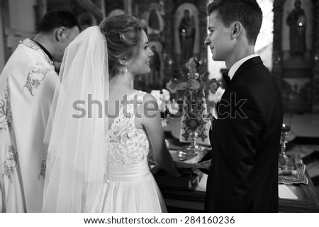 classic wedding ceremony of stylish young luxury bride and groom in the ancient old church