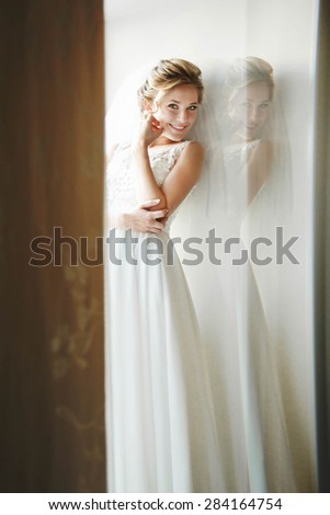 stylish luxury gorgeous blonde bride posing on the background hotel room