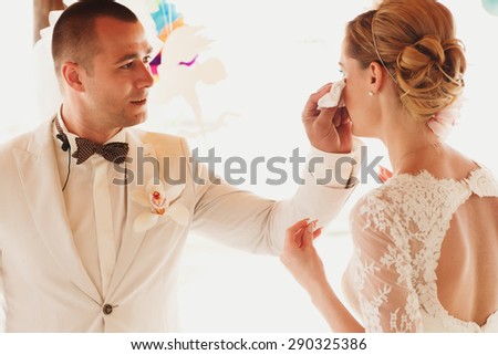 beautiful  gorgeous blonde bride crying  and stylish groom, hawai  colorful sand ceremony  on cyprus
