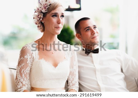 beautiful gorgeous blonde bride crying and stylish groom celebrating wedding on the restaurant terrace