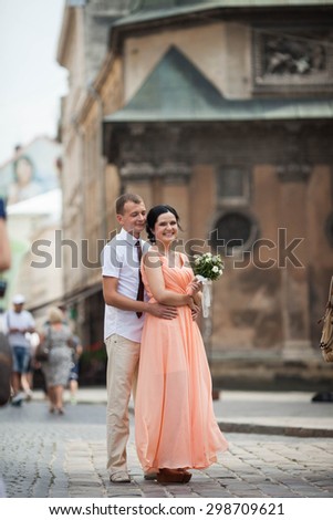 beautiful young happy stylish caucasian bride and groom on the background impressive architecture, Lviv, summer