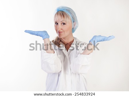 Portrait of young beautiful doctor holding something in hand