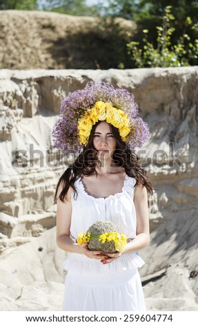 Portrait of young beautiful woman circlet of flowers on head outdoors