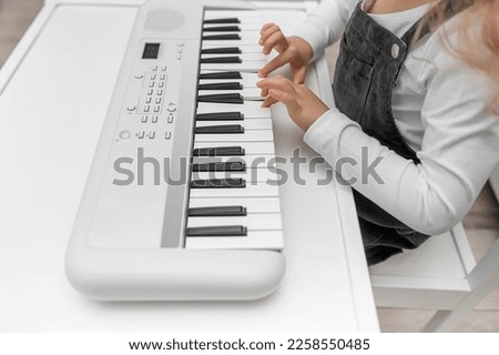 Children's hands on the keys of the synthesizer. Close-up. Сток-фото © 