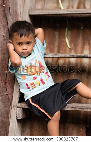 BANGKOK, THAILAND - December 13: An unidentified Asian boy sits on stairs on December 13, 2014 in Bangkok, Thailand.