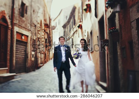 romantic gentle luxury brunette bride and groom are walking at the streets of tivoli italy