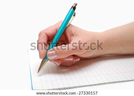 A hand holding a pen and writing in the exercise book
