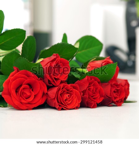 Red bouquet of roses on a white table. With eye level with copy space