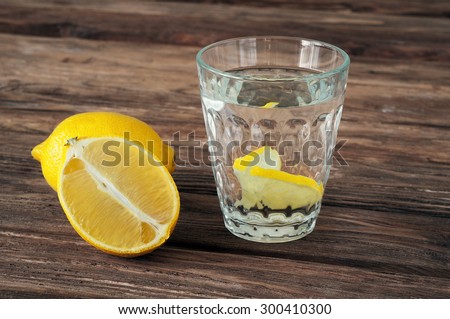 glass of water with lemon slices on a wooden background. Copy space. Free space for text