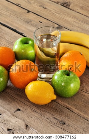fruit with a glass of water on a wooden table. Orange, apple, banana, lemon. Top view. closeup. Free space for text