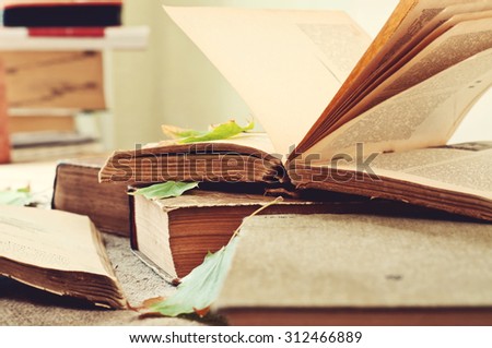 Old books. Old open book close-up with autumn maple leaves on the table. Copy space. Free space for text