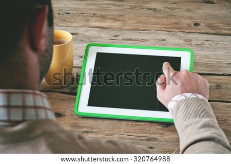 Man working with a tablet computer. Male presses on the blank screen tablet computer. Concept man working from home using tablet computer. Free space for text. Top view. Copy space