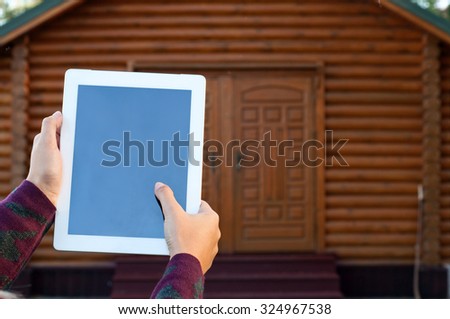 Tablet computer in female hands. Woman clicks on screen tablet computer. Concept - smart home. Copy space