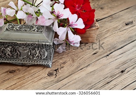 bouquet of beautiful flowers with the vintage jewelry box and book on wooden background closeup. Top view