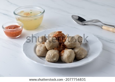 Selected Focus Bakso Pentol Ayam Kuah or Chicken Meatball, Indonesian Typical from East Java. Made by Minced Chicken, Tapioca Flour. Served on plate toping fried onion with chilli sauce Foto d'archivio © 