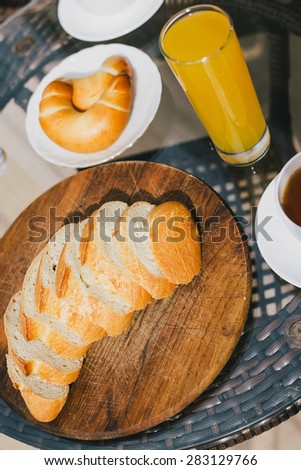 Breakfast for two persons on a balcony with beautiful view on the ocean. Fresh tea, juice, croissants, jam and bread