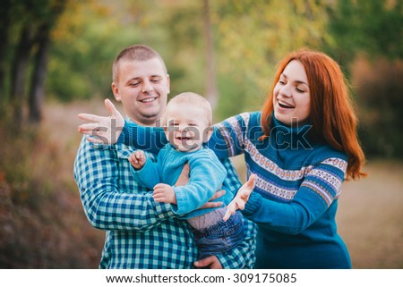 Happy family in blue stylish clothes walking in autumn forest