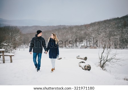 Young happy couple walking in a winter countryside