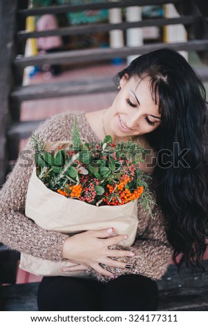 Young woman holding paper bag with ingredients for Christmas or Thanksgiving Day wreath