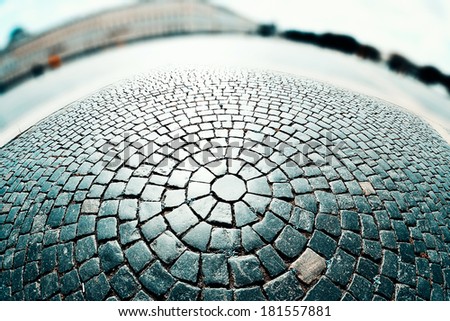 cobblestone pavement on a square with defocused background, cross-processing effect