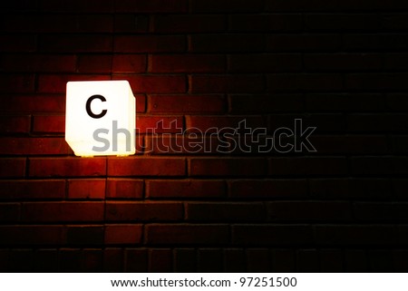 Street number on a brick wall at night.