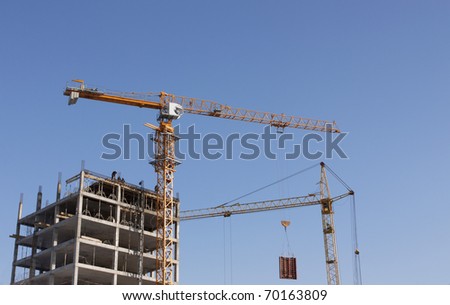 On the image there are two cranes. They ; construct   house.