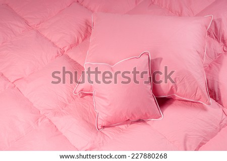 Pink cotton fluff two pillows on big duvet without cover, eiderdown filled with fluff or feathers. Horizontal orientation, nobody.
