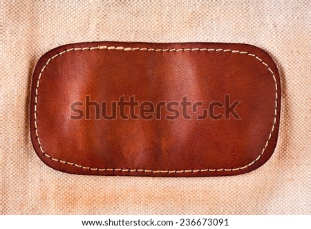 Leather patch linen cloth abstract, brown detail on beige linen material of handbag, textured background in horizontal orientation, nobody.