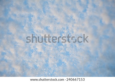 Melting snow and water texture, condensation on window glass, transparent glass in winter and ice with white snow in contact with morning warm sunlight. Horizontal orientation, nobody.