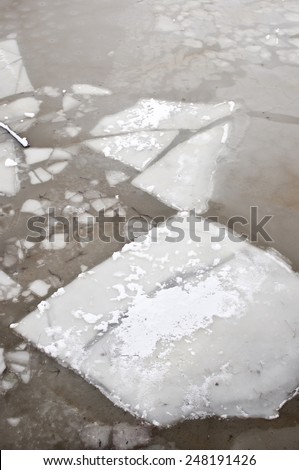 Ice floe sheets floating at frozen lake in winter season in Poland, vertical orientation, nobody.