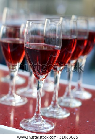 Wedding banquet red wine in glass. After the wedding guest went for a little reception with alcohol in wineglasses. Transparent classic stemmed glass vertical orientation, nobody in frame.
