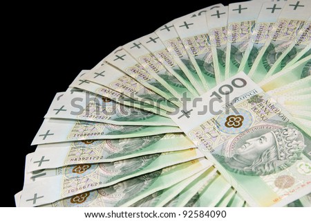 Fan of one hundred polish zloty paper banknotes lying on black background, horizontal orientation, nobody.