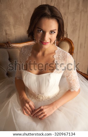 Wedding Celebration. Beautiful young bride in white wedding dress. Indoor studio with beautiful furniture.